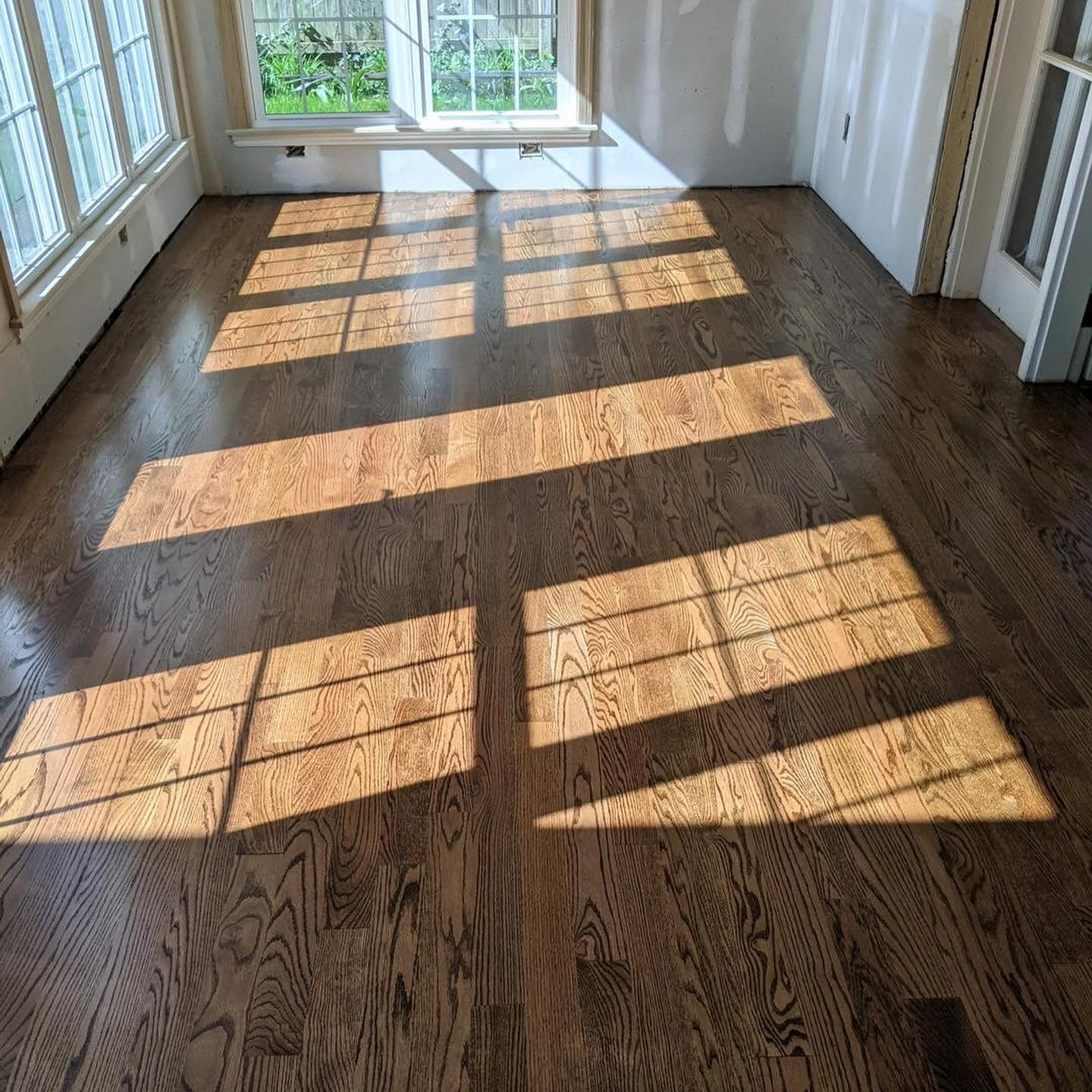 Dark hardwood flooring in sun drenched living room